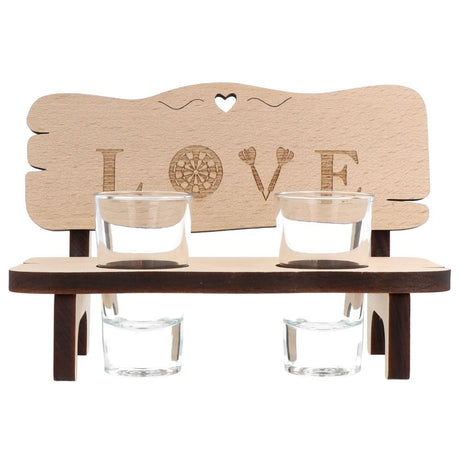 Holzbank mit zwei Schnapsgläsern und dem Schriftzug Love auf der Rückenlehne