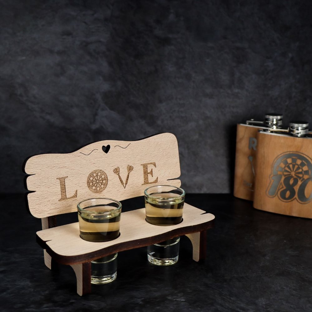 Holzbank mit zwei Schnapsgläsern und dem Schriftzug Love auf der Rückenlehne